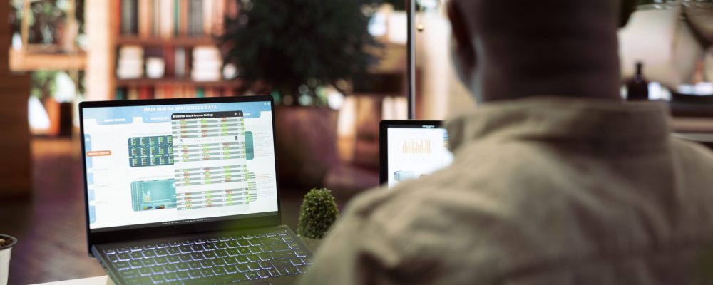 Accountancy specialist examining business funds and profit from annual sales invoices, studying market statistics data on a laptop at home. Business owner creating a new investment plan.