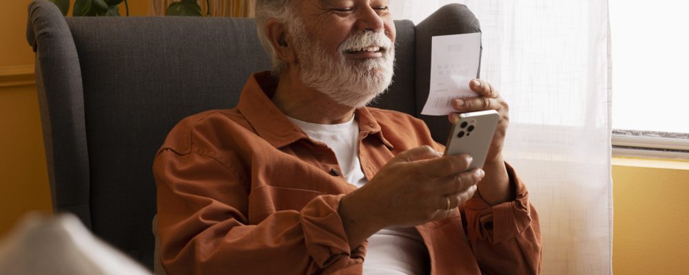 vista-lateral-velho-segurando-smartphone